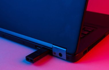 USB flash diski olan mavi-pembe renkli bir dizüstü bilgisayar.