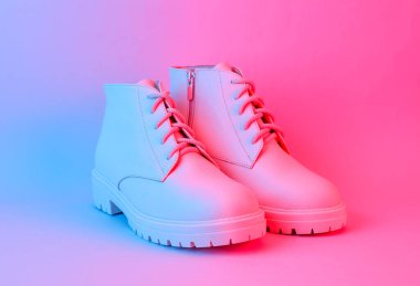 Mavi-kırmızı neon ışıklı beyaz deri çizmeler. Yaratıcı moda hala hayat