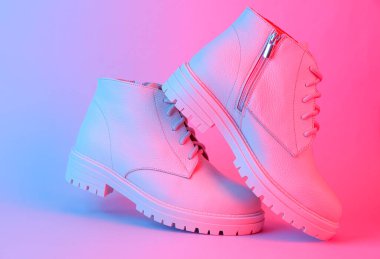 Mavi-kırmızı neon ışıklı beyaz deri çizmeler. Yaratıcı moda hala hayat