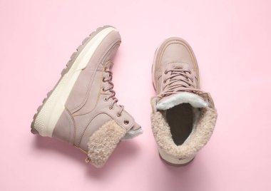 Pembe arka planda kadın kış botları. Üst görünüm