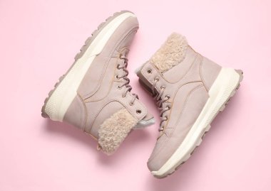 Pembe arka planda kadın kış botları. Üst görünüm