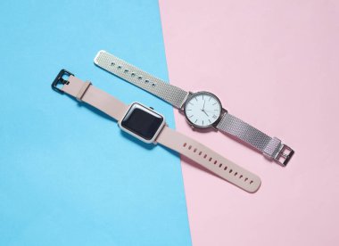 Mavi-pembe arka planda modern akıllı ve analog saatler. Üst görünüm