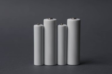 Koyu gri arka planda AAA ve AA bataryaları. Tasarım için model