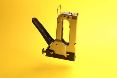 Sarı arkaplanda yüzen inşaat zımbası