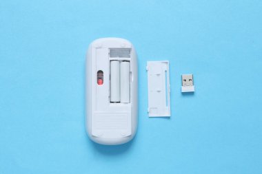 Mavi arkaplanda kablosuz bilgisayar faresi ve piller