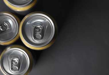 Bira, soda ya da enerji içeceği için alüminyum kutular koyu gri arka planda. Üst görünüm