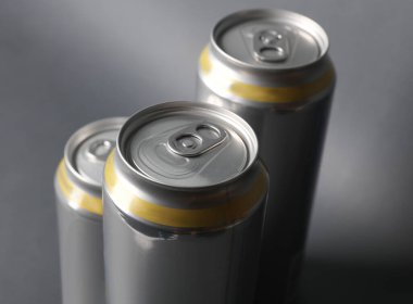 Koyu gri arka planda bira, soda veya enerji içecekleri için alüminyum kutular.