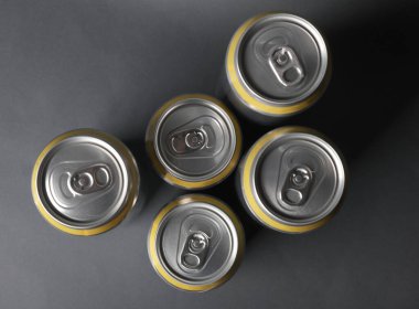 Bira, soda ya da enerji içeceği için alüminyum kutular koyu gri arka planda. Üst görünüm