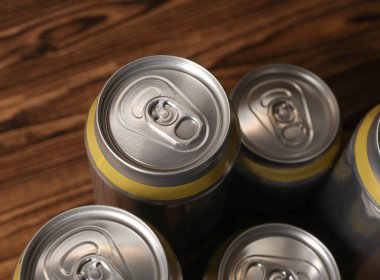 Bira, soda ya da enerji içeceği için alüminyum kutular ahşap arka planda.