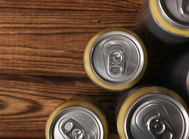 Bira, soda ya da enerji içeceği için alüminyum kutular ahşap arka planda.