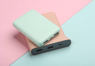 Mavi pastel arka planda iki plastik güç bankası