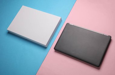 Mavi-pembe arka planda beyaz karton kutulu yeni siyah modern laptop..