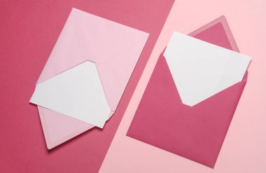 Pembe arkaplanda beyaz boş harfler olan pembe zarflar. Yaratıcı yerleşim