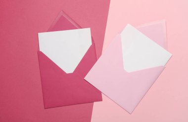 Pembe arkaplanda beyaz boş harfler olan pembe zarflar. Yaratıcı yerleşim