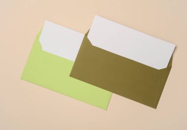 Bej arkaplan üzerinde beyaz boş harfler olan renkli zarflar. Yaratıcı yerleşim