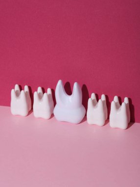 Pembe arka planda plastik diş modelleri. Yaratıcı yerleşim