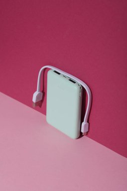 Pembe arka planda kablolu plastik güç bankası