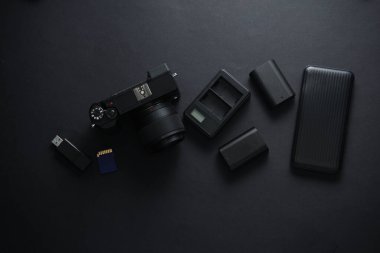Siyah arka planda modern fotoğrafçı ekipmanları. Siyah takımlar ve aksesuarlar. Düz yatıyordu. Üst görünüm