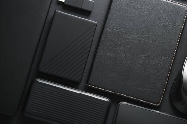 Laptop, dizüstü bilgisayar, güç bankası, harici hard disk, siyah arka planda USB flash disk. Çalışma alanı. Düz yatıyordu