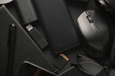 Siyah arka planda modern siyah cihazların ve aksesuarların düz kompozisyonu vardı. Üst görünüm.