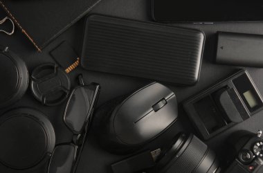 Siyah arka planda modern siyah cihazların ve aksesuarların düz kompozisyonu vardı. Üst görünüm.