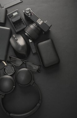 Siyah arka planda modern siyah cihazların ve aksesuarların düz kompozisyonu vardı. Üst görünüm.