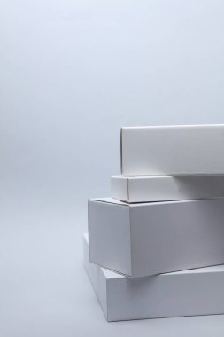Beyaz arkaplandaki sunum ürünleri için farklı şekillerde beyaz karton kutular. Tasarım için model.