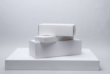 Beyaz arkaplandaki sunum ürünleri için farklı şekillerde beyaz karton kutular. Tasarım için model.