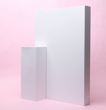 Pembe arka plandaki sunum ürünleri için farklı şekillerde beyaz karton kutular. Tasarım için model.