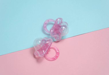 Mavi-pembe arka planda iki bebek emziği. Düz yatıyordu