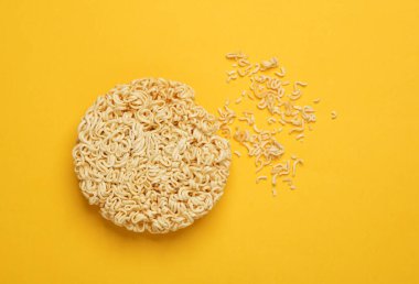 Dry instant noodles on yellow background