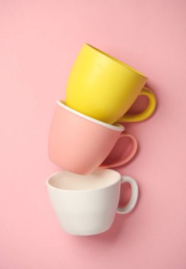 Pembe arka planda üç seramik bardak.