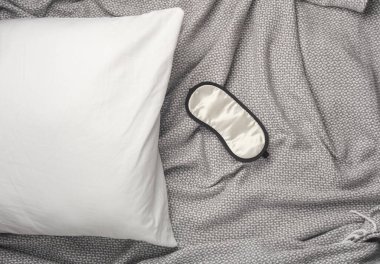 Battaniyenin üzerinde uyku maskesi olan yastık. İyi uykular.