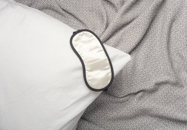 Battaniyenin üzerinde uyku maskesi olan yastık. İyi uykular.