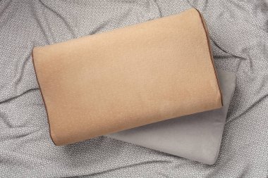Gri bir battaniyeye iki ortopedik yastık.