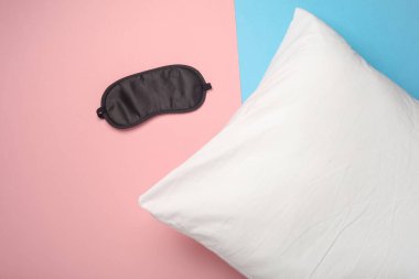 Pembe arka planda yastıklı uyku maskesi. Sağlıklı uyku konsepti