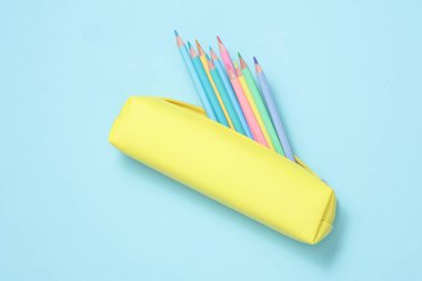 Mavi arka planda renkli kalemleri olan bir okul kalem kutusu. Okul konseptine dönelim.