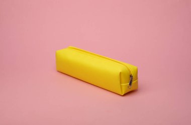 Pembe arka planda sarı okul kalem kutusu.