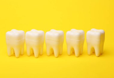 Sarı arka planda plastik diş modelleri