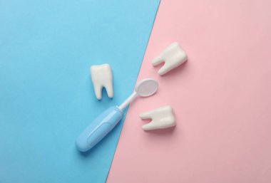 Diş hekimine git, ağız boşluğu konseptini hallet. Mavi arka planda oyuncak diş aynası ve diş modelleri