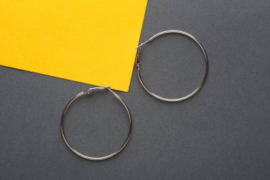 Gri sarı arka planda gümüş küpeler.