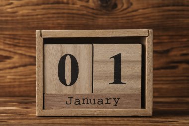 Ahşap blok takvimi ve ahşap zemin üzerinde tarih Ocak 01