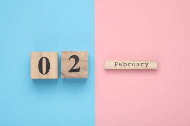 Ahşap blok takviminde tarih 02 Şubat, pembe mavi arka plan. Üst Manzara. Düz yatıyordu