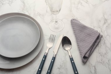 Tabaklar, mermer zemin üzerinde havlu olan çatal bıçak takımı. Tablo ayarı.