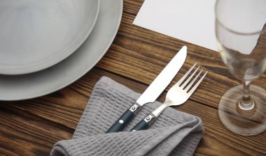 Ahşap arka planda sofra takımı için tabak ve çatal bıçak takımı.