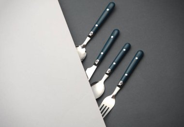 Beyaz gri arka planda çatal bıçak seti. Düz yatıyordu. Yaratıcı yerleşim