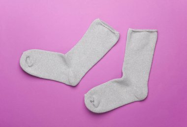 Mor arka planda bir çift gri çorap.