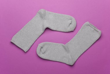 Mor arka planda bir çift gri çorap.