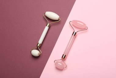 Pembe bordo arka planda yaşlanmayı önleyen yüz masajı için masaj makineleri.