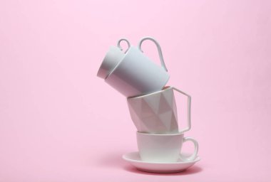 Pembe arkaplanda farklı beyaz bardaklar yığını